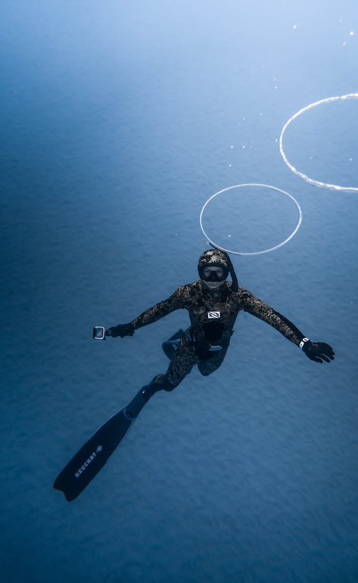 Unrecognizable person diving in blue seawater